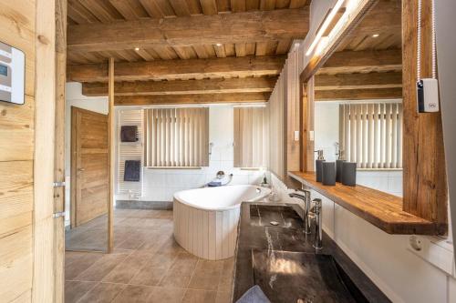 a bathroom with a tub and a sink at Almdorf Auszeit Fageralm in Forstau