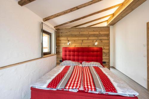 a red bed in a room with a red headboard at Almdorf Auszeit Fageralm in Forstau