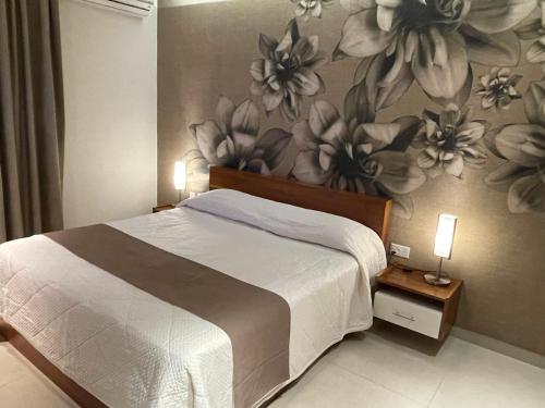 a bedroom with a bed with a flower mural on the wall at Deluxe Apartment with pool in the heart of St Pauls Bay in St Paul's Bay