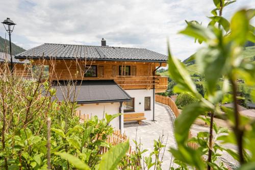 a wooden house with a black roof at Almdorf Auszeit Fageralm in Forstau