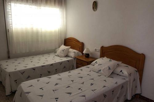 dwa łóżka w pokoju z oknem w obiekcie Apartamento céntrico vistas al mar con ascensor w mieście Peñíscola
