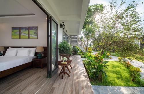 a bedroom with a bed and a garden at Bai Dinh Riverside Resort & Spa in Ninh Binh