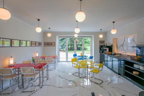 a dining room with tables and chairs and a kitchen at Hotel & Gallery Kopacka in Svitavy