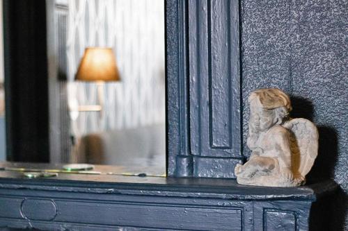 a statue of a woman sitting on top of a dresser at Hôtel Saint Florent in Orange