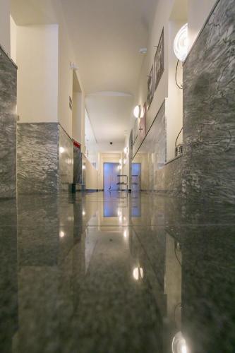 a hallway with marble floors and a blue door at Hotel & Gallery Kopacka in Svitavy