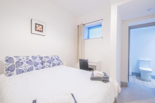 a white bedroom with a bed and a toilet at Portrush Marine Apartments flat1 in Portrush