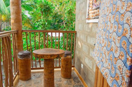 a table and two stools on a balcony at Residêncial Tamarindos in M. Peixe