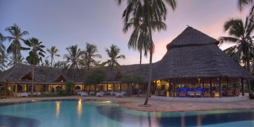 
a beach with palm trees and palm trees at Bluebay Beach Resort & Spa in Kiwengwa
