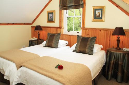 duas camas num quarto com dois candeeiros e uma maçã vermelha em Evergreen Lodge em Stellenbosch