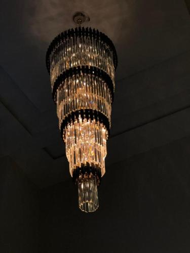 a large chandelier is hanging from a ceiling at Hotel Silver Oaks in Narān