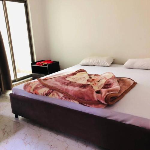 a bed with a blanket on it in a room at Hotel Silver Oaks in Narān