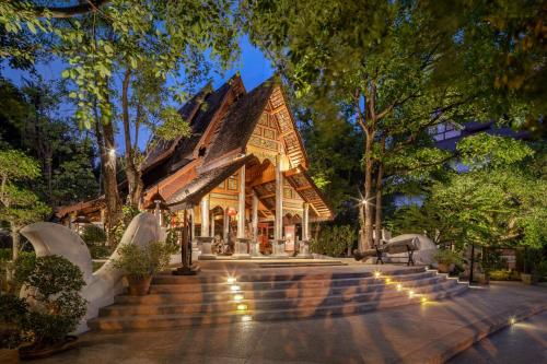 a home with a large wooden house with stairs at Khum Phaya Resort & Spa Boutique Collection in Chiang Mai