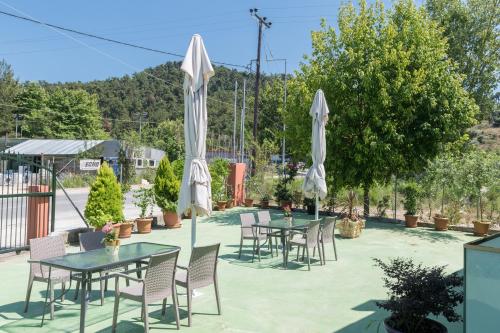a patio with tables and white umbrellas at Villa Laskaridis in Limenas