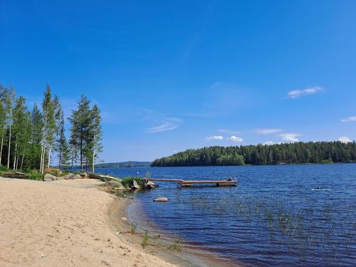 a beach with a dock in the middle of a lake at Tahko Hills in Tahkovuori