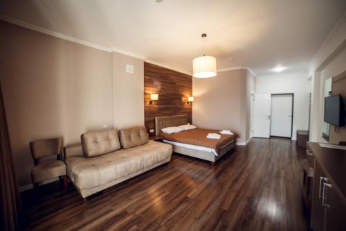a living room with a couch and a bed at Кайзервальд Клуб in Karpaty