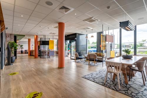 an office lobby with a table and chairs at B&B HOTEL Le Port Marly Saint Germain en Laye in Le Port-Marly