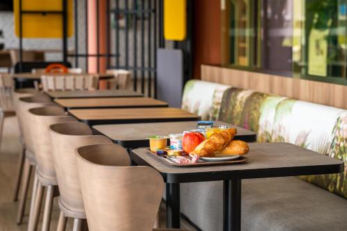 a row of tables with bread and fruit on them at B&B HOTEL Le Port Marly Saint Germain en Laye in Le Port-Marly