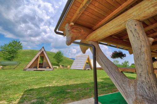 a view from the porch of a cabin with a thatched roof at Glamping Brodej in Vitanje