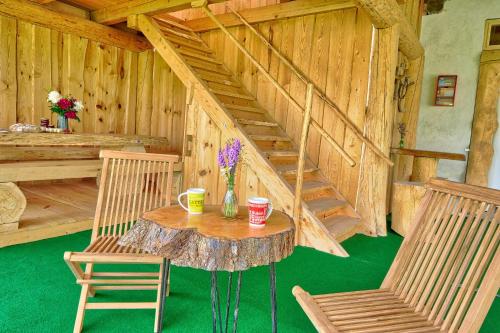 a room with a table and two chairs and a staircase at Glamping Brodej in Vitanje