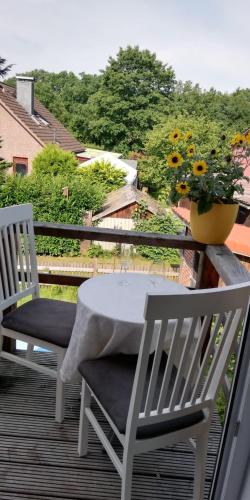 two chairs and a table on a balcony with a plant at Apartment bei Paulchen in Schneverdingen