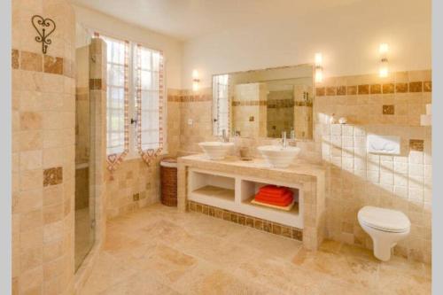 La salle de bains est pourvue de 2 lavabos, d'une douche et de toilettes. dans l'établissement Le clos des pins, vue mont Ventoux, à Roaix