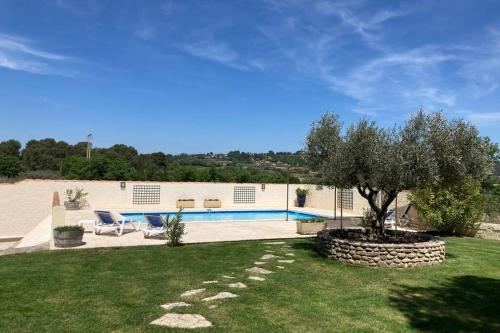 une villa avec piscine dans une cour dans l'établissement Le clos des pins, vue mont Ventoux, à Roaix