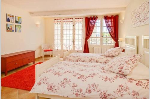 - une chambre avec 2 lits et un tapis rouge dans l'établissement Le clos des pins, vue mont Ventoux, à Roaix