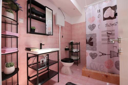 a pink bathroom with a toilet and a shower at Pool-Apartments Porec (4400) in Poreč