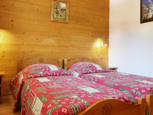 - une chambre avec 2 lits dans une pièce dotée de murs en bois dans l'établissement Appartement Méribel, 2 pièces, 5 personnes - FR-1-182-5, à Méribel