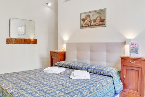 une chambre avec un lit avec deux serviettes dessus dans l'établissement Keith Haring Cozy Apartment, à Pise