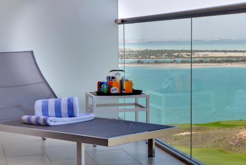 a bench in a room with a view of the ocean at Park Inn by Radisson Abu Dhabi Yas Island in Abu Dhabi