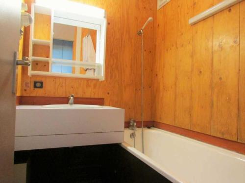 a bathroom with a tub and a sink and a mirror at Appartement Bellentre, 2 pièces, 5 personnes - FR-1-329-23 in Bellentre