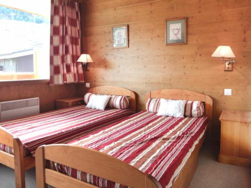 2 camas en una habitación con paredes de madera en Appartement Méribel, 2 pièces, 5 personnes - FR-1-182-27, en Méribel
