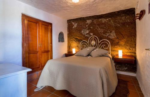 a bedroom with a bed with two pillows on it at Casa Cueva El Caidero in Artenara