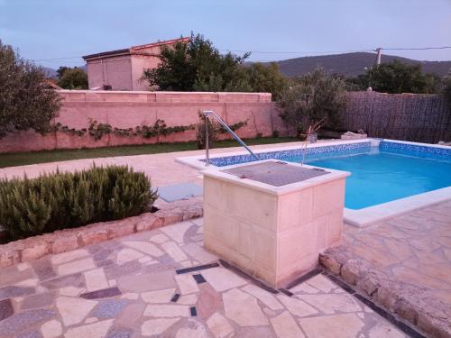 a swimming pool with a fountain in a yard at Villa Frane in Kneževići