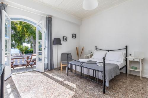 um quarto com uma cama e uma varanda em PSARIANOS BEACHFRONT APARTMENTS em Panormos Skopelos