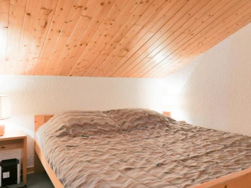 a bed in a room with a wooden ceiling at Appartement Méribel, 3 pièces, 7 personnes - FR-1-182-95 in Méribel