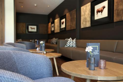 a restaurant with couches and tables and chairs at JUFA Hotel Salzburg in Salzburg