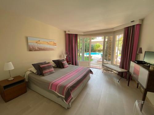 une chambre avec un lit et une porte coulissante en verre dans l'établissement Villa privée indépendante et Luxueuse au calme, à Narbonne