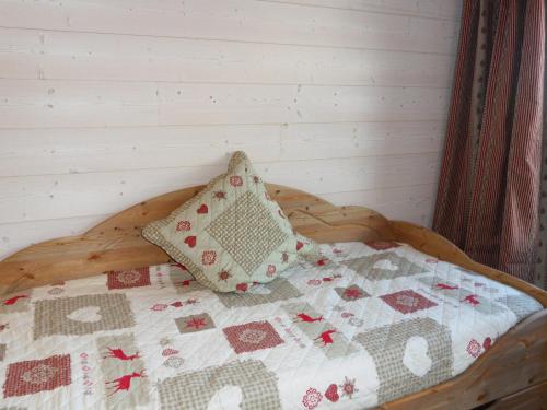 a bed with a quilt and two pillows on it at Studio Méribel, 1 pièce, 3 personnes - FR-1-182-43 in Méribel