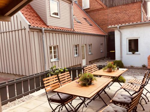 a patio with wooden tables and chairs and a building at Ferienwohnung C im Ferienhaus Antika in Ratzeburg