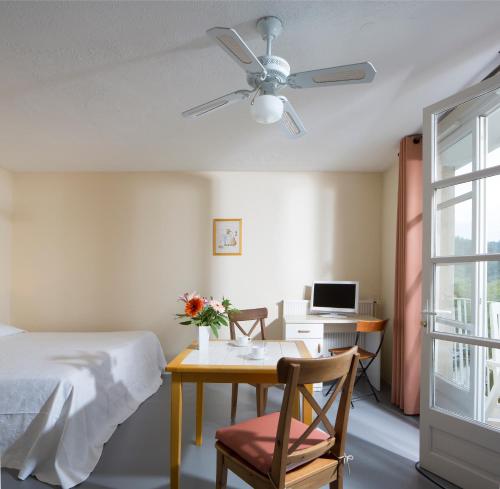 a bedroom with a bed and a desk with a computer at Résidences LES HAUTES PLAINES in Gréoux-les-Bains