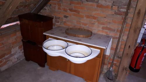 ein WC in einem Zimmer mit Ziegelwand in der Unterkunft Bett im Heu auf Bauernhof Gemeinschaftsbad Schlafsäcke in Hausbreitenbach