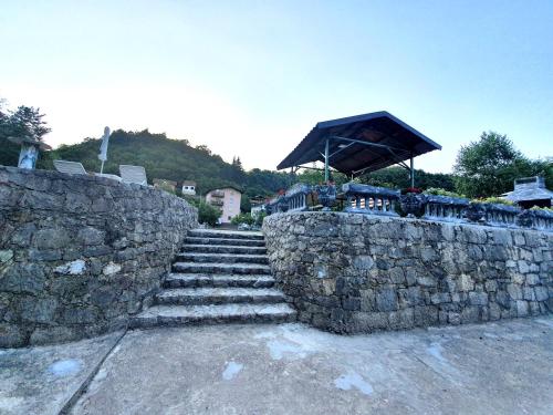 a stone retaining wall with a stone stairway at Saraj Guest House in Kulen Vakuf