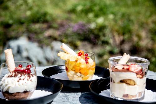 Trois desserts sur des assiettes noires sur une table dans l'établissement Gîte du Prilet, à Saint-Luc