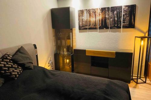 a bedroom with a bed and two paintings on the wall at Schönes ruhiges App mit Panoramablick auf den Harz in Braunlage