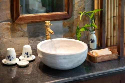 a bowl sink on a counter with a faucet at Bai Dinh Riverside Resort & Spa in Ninh Binh