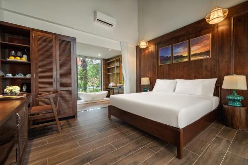 a bedroom with a bed and a bathroom with a tub at Bai Dinh Riverside Resort & Spa in Ninh Binh