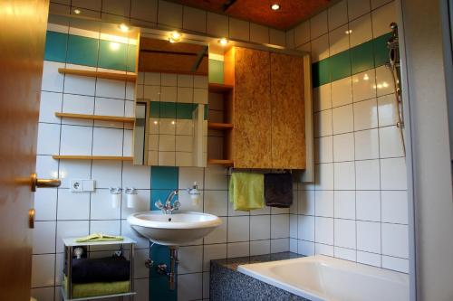 ein Badezimmer mit einem Waschbecken und einer Badewanne in der Unterkunft Appart Manuela in Arzl im Pitztal
