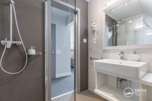 a bathroom with a sink and a shower at TATRA SUITES Boutique Suites Deforte Star View 301 in Poprad